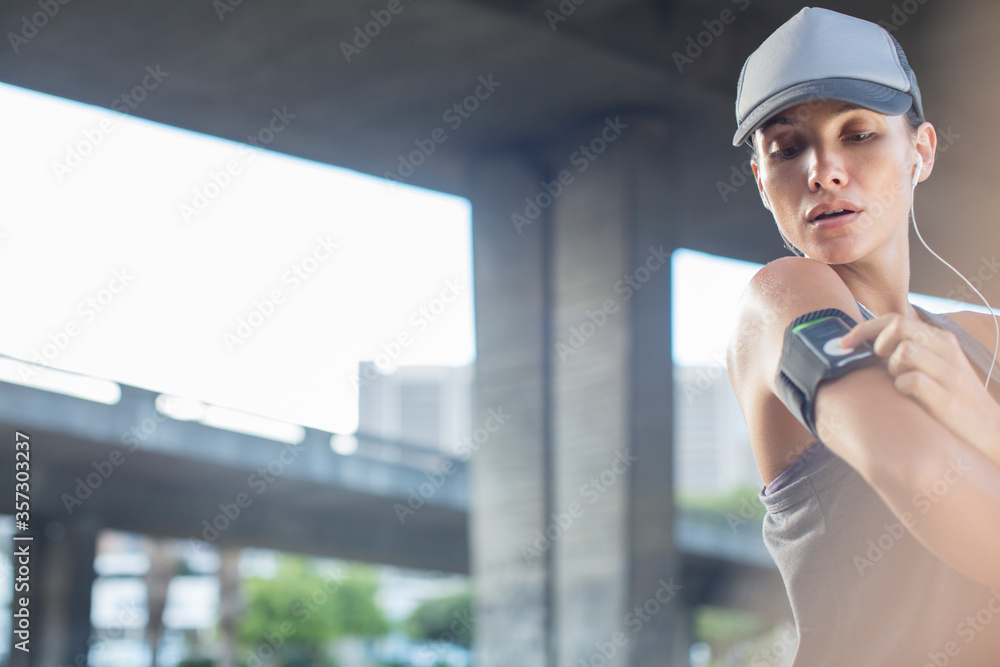 Fototapeta premium Woman playing music before exercising