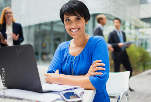 Businesswoman working on laptop outside of office building