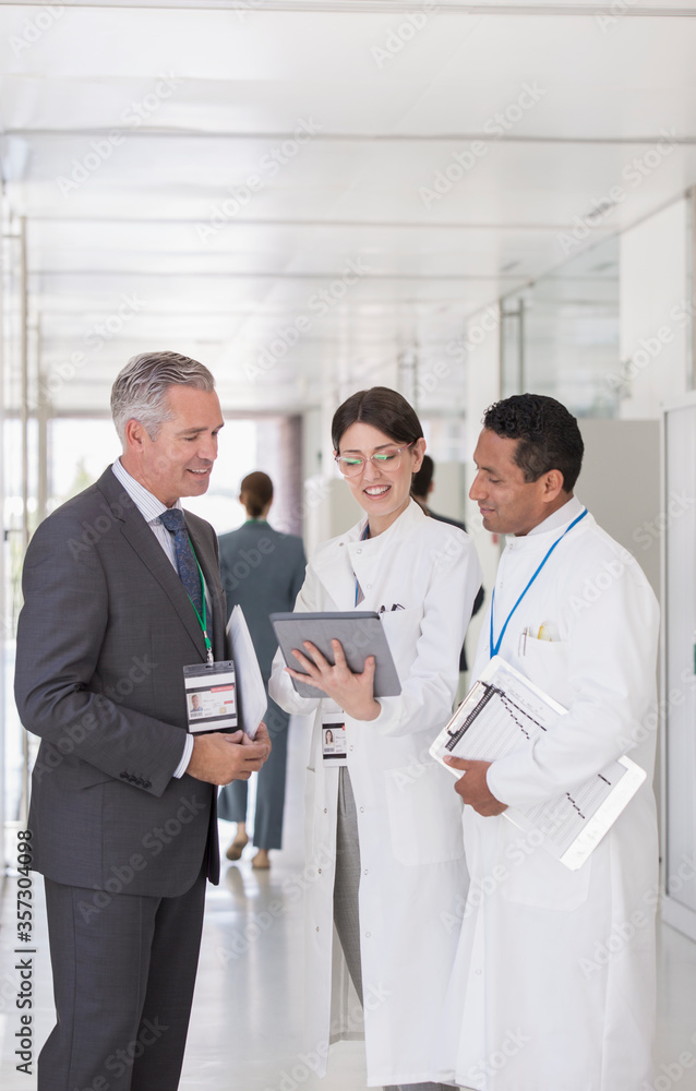 Scientists and businessman using digital tablet in hallway Scientists and businessman using digital tablet in hallway