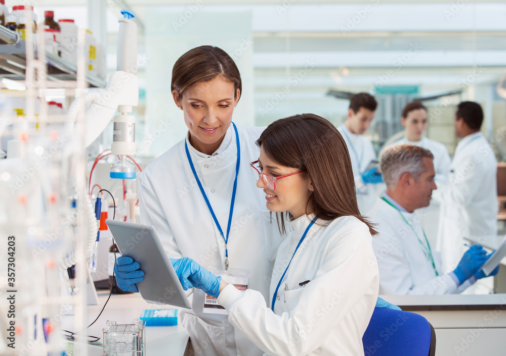 Scientists using digital tablet in laboratory Scientists using digital tablet in laboratory