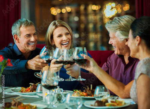 People toasting with red wine in restaurant