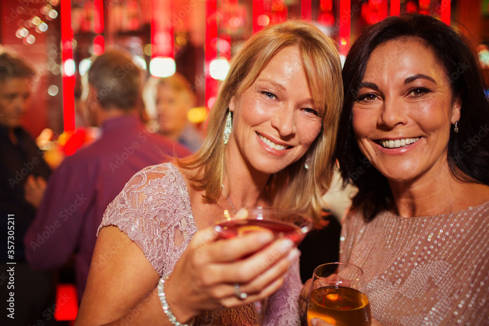 Portrait of smiling mature women enjoying drink in bar