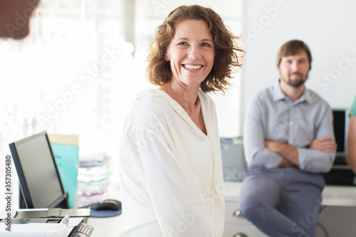 Portrait of businesswoman in office, colleague in background