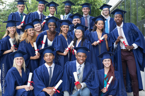 Photography Portrait of university students in graduation gowns outdoors