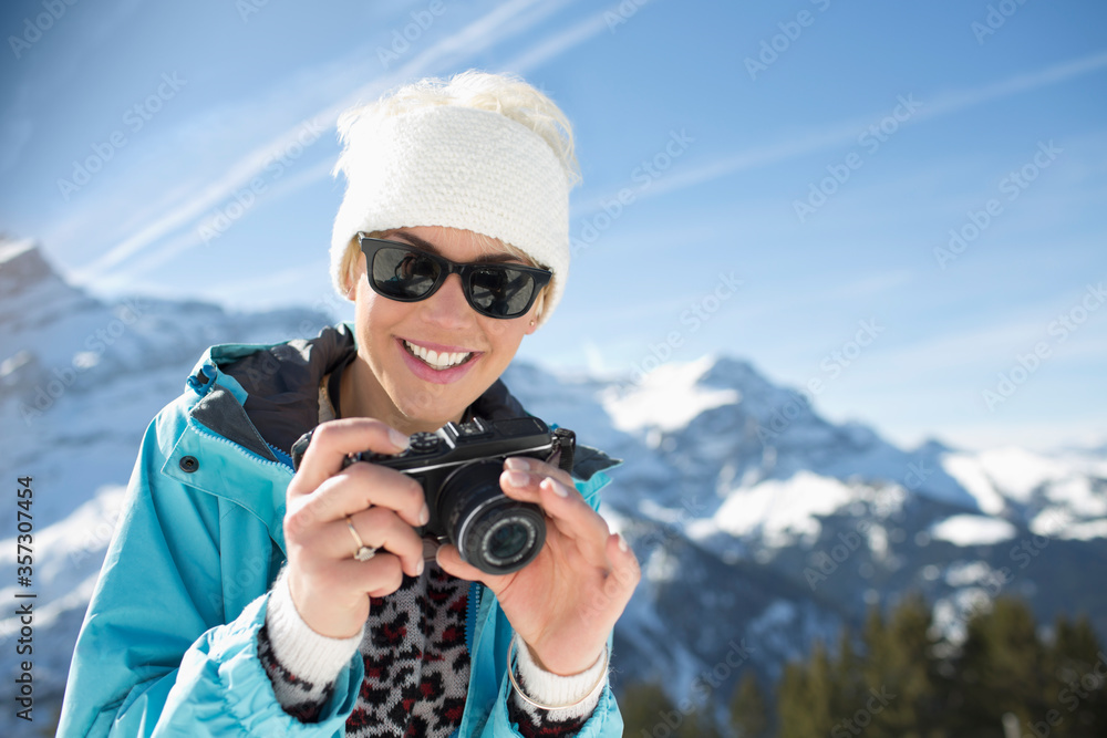 Fototapeta premium Portrait of smiling woman with camera at mountains