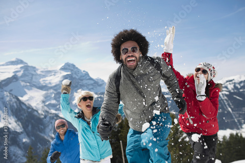 Friends enjoying snowball fight at mountain