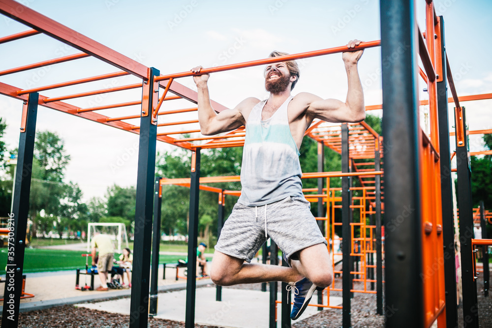 strong athlete doing pull-up on horizontal bar. Muscular man doing pull ups on horizontal bar in park. Gymnastic Bar During Workout. training strongmanoutdoor park gym. Man Doing Exercise gym Outdoor strong athlete doing pull-up on horizontal bar. Muscular man doing pull ups on horizontal bar in park. Gymnastic Bar During Workout. training strongmanoutdoor park gym. Man Doing Exercise gym Outdoor
