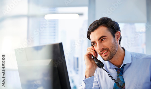 Man using landline phone in office photo