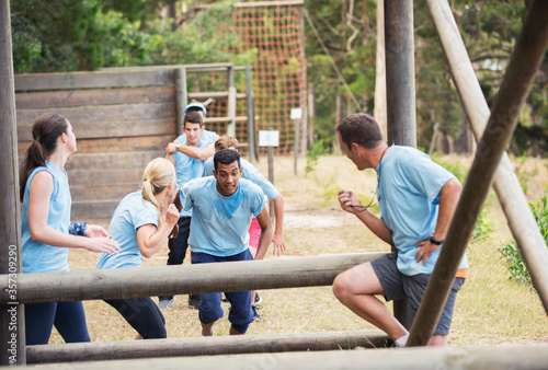 Teammates cheering man on boot camp obstacle course © Sam Edwards/KOTO