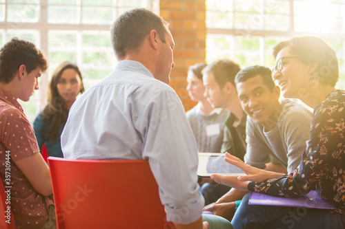 Foto Woman with digital tablet speaking to man at group therapy session