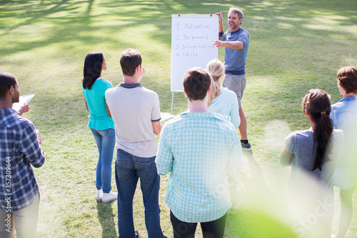 Man leading meeting at flipchart in field