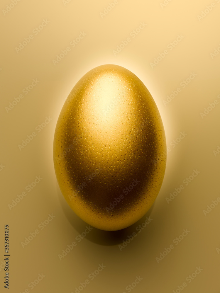 Overhead view of golden egg on gold background still life Overhead view of golden egg on gold background still life