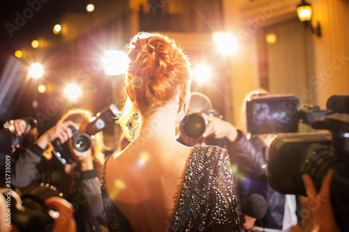 Celebrity being photographed by paparazzi photographers at event photo