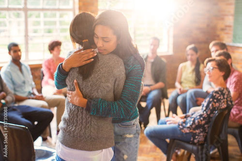 Women hugging in group therapy session