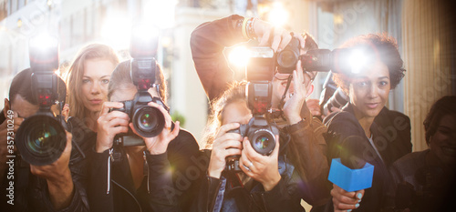 Portrait of paparazzi in a row with cameras and microphone photo