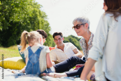 Multi-generation family relaxing on blanket in sunny field