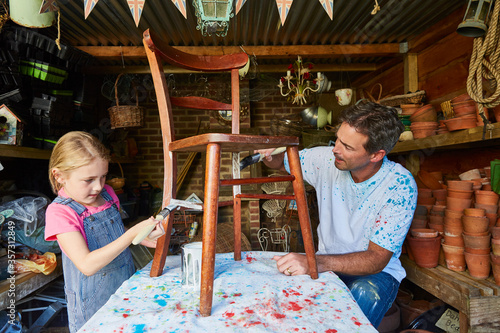 Fotografía Father and daughter painting chair in workshop