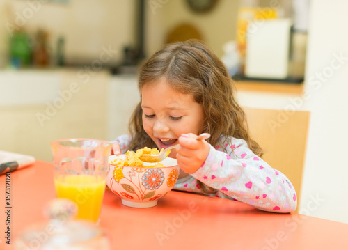 Girl eating cereal at breakfast table