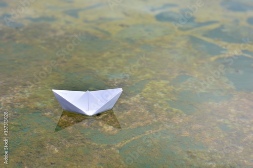 barco de papel sobre el agua de un estanque