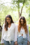 Dos chicas vestidas de blanco en un bosque