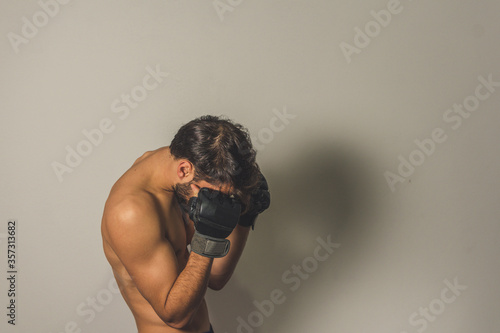 portrait of a young man trainning with boxing gloves