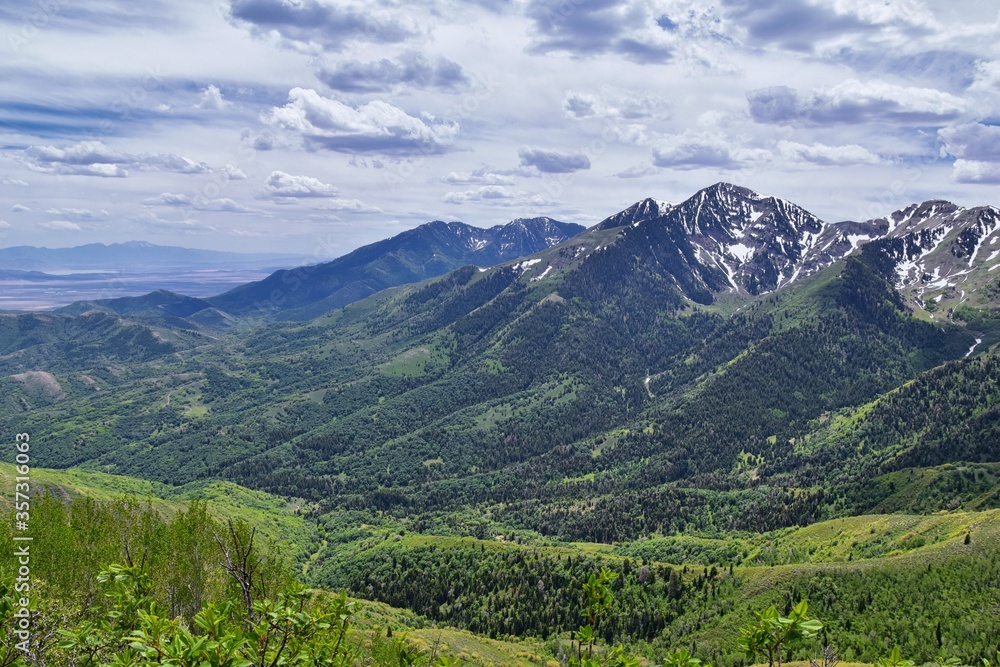 Obraz premium Rocky Mountain Wasatch Front peaks, panorama landscape view from Butterfield Canyon Oquirrh range toward Provo, Tooele Utah Lake by Rio Tinto Bingham Copper Mine, Great Salt Lake Valley in spring. Uta