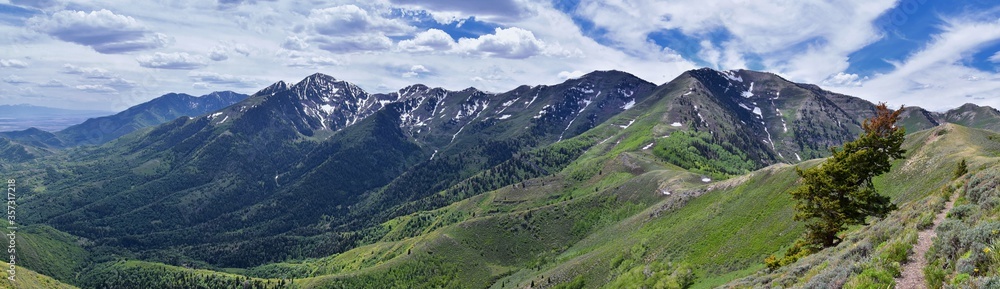 Fototapeta premium Rocky Mountain Wasatch Front peaks, panorama landscape view from Butterfield Canyon Oquirrh range toward Provo, Tooele Utah Lake by Rio Tinto Bingham Copper Mine, Great Salt Lake Valley in spring. Uta