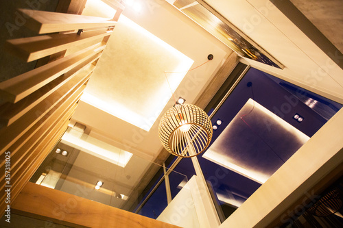 фотографія Illuminated tray ceiling and modern pendant light hanging in luxury foyer