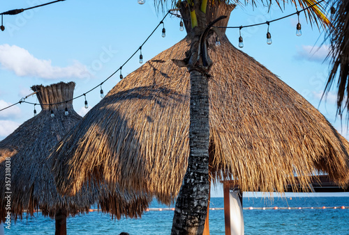 Tropical resourt beach under palm trees and beach huts in Mexico. photo