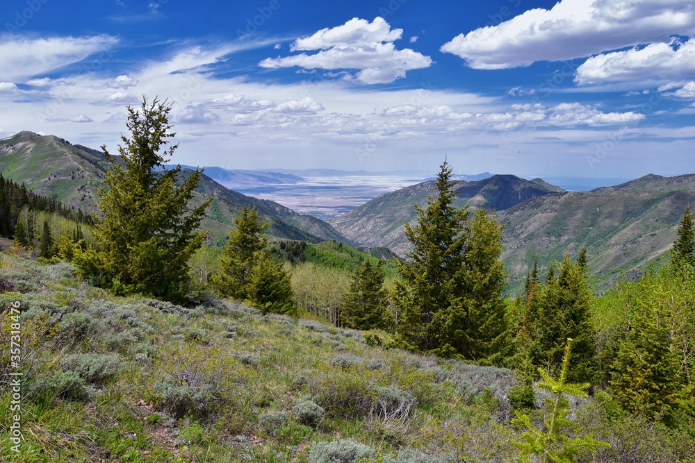 Obraz premium Rocky Mountain Wasatch Front peaks, panorama landscape view from Butterfield Canyon Oquirrh range toward Provo, Tooele Utah Lake by Rio Tinto Bingham Copper Mine, Great Salt Lake Valley in spring. Uta