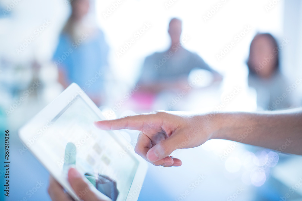 Close up businessman pointing to digital tablet in meeting Close up businessman pointing to digital tablet in meeting