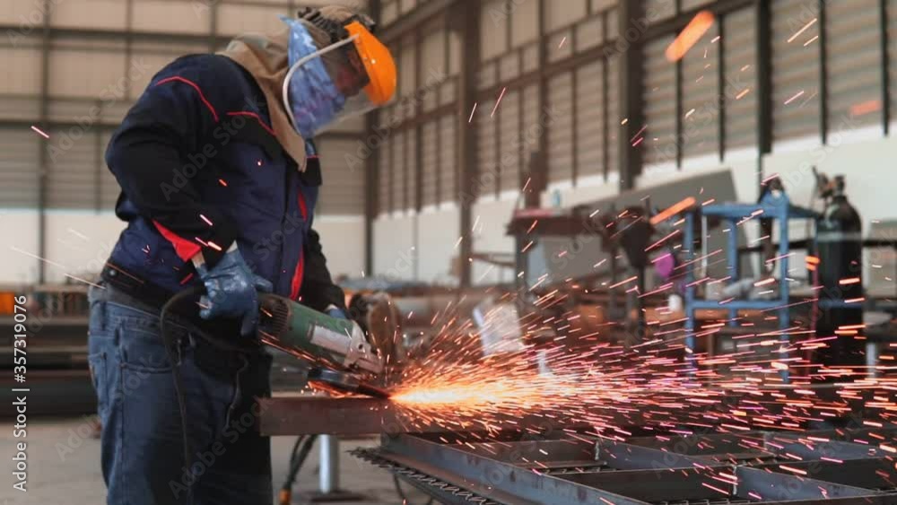 Electric wheel grinding on steel structure in factory