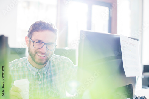 Portrait enthusiastic creative businessman drinking coffee at computer