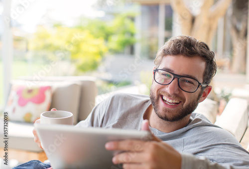 Portrait smiling man drink coffee and using digital tablet