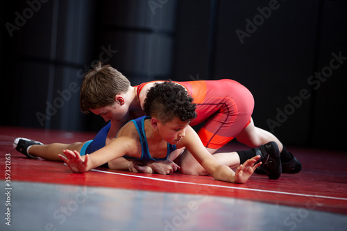 Konstfotografi Wrestlers in red and blue singlets practicing on a red mat.