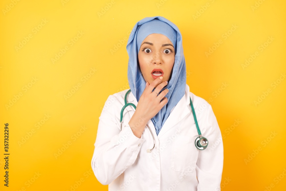 Headshot of nervous puzzled doctor man, opens mouth from surprise, reacts on sudden news, wears medical uniform, isolated over yellow background. People and facial expressions. Headshot of nervous puzzled doctor man, opens mouth from surprise, reacts on sudden news, wears medical uniform, isolated over yellow background. People and facial expressions.