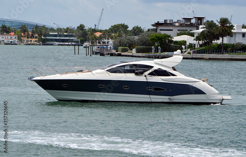 Black and white motor yacht idling on the Florida Intra-Coastal Waterway off Miami Beach.