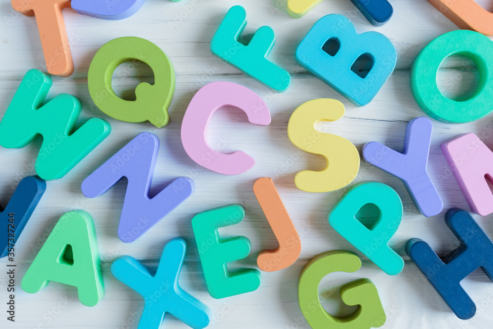 Close up Multicolored wooden letters with ABC on white wooden background. Set of toys for studying alphabet. Education, back to school concept. Top view, copy space Close up Multicolored wooden letters with ABC on white wooden background. Set of toys for studying alphabet. Education, back to school concept. Top view, copy space