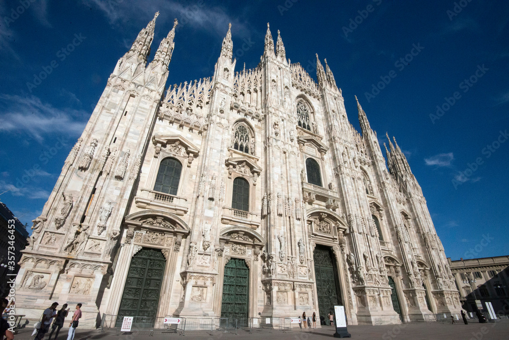 perspective of duomo di milano cathedral italy with blue sky and clouds
