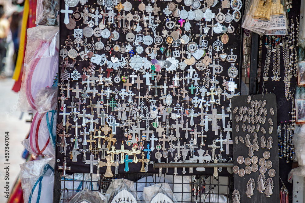 Many crosses and medals of virgins at a street vendor stall in Lujan, Buenos Aires, Argentina