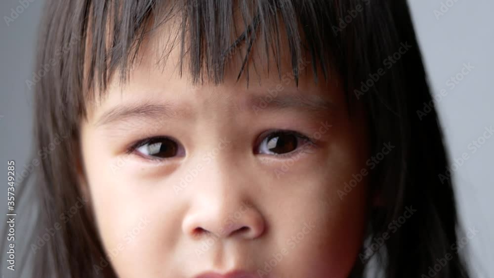 Portrait face of Asian little child girl with sad expression on dark background. Portrait face of Asian little child girl with sad expression on dark background.