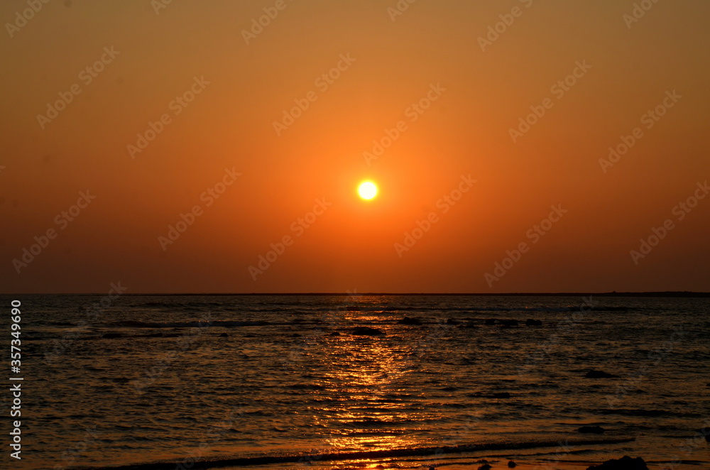 Fototapeta premium Beautiful sunset over the sea with a blurred view at St. Martins Island. The sunlight reflecting on the seawater. Blur Background with golden and reddish sunset abstract. Famous place for Tourism.