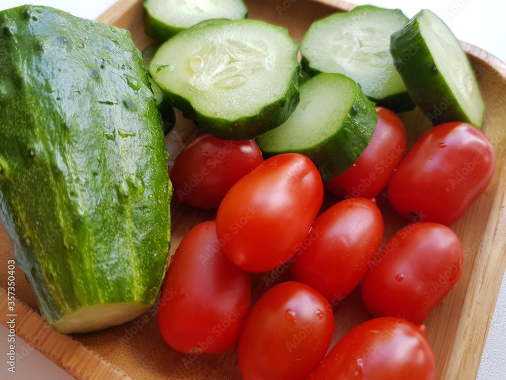 Tomatoes and cucumbers lie on a plate Tomatoes and cucumbers lie on a plate