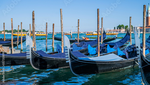 Gondolas moored by Saint Mark square with San Giorgio di Maggiore church in the background in Venice, Italy. Architecture and landmarks of Venice.