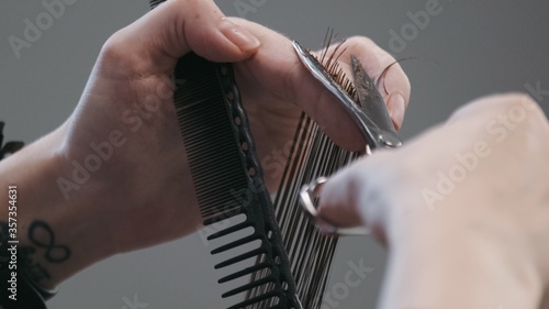 Professional female hairstylist combing and cutting man hair. Slow motion