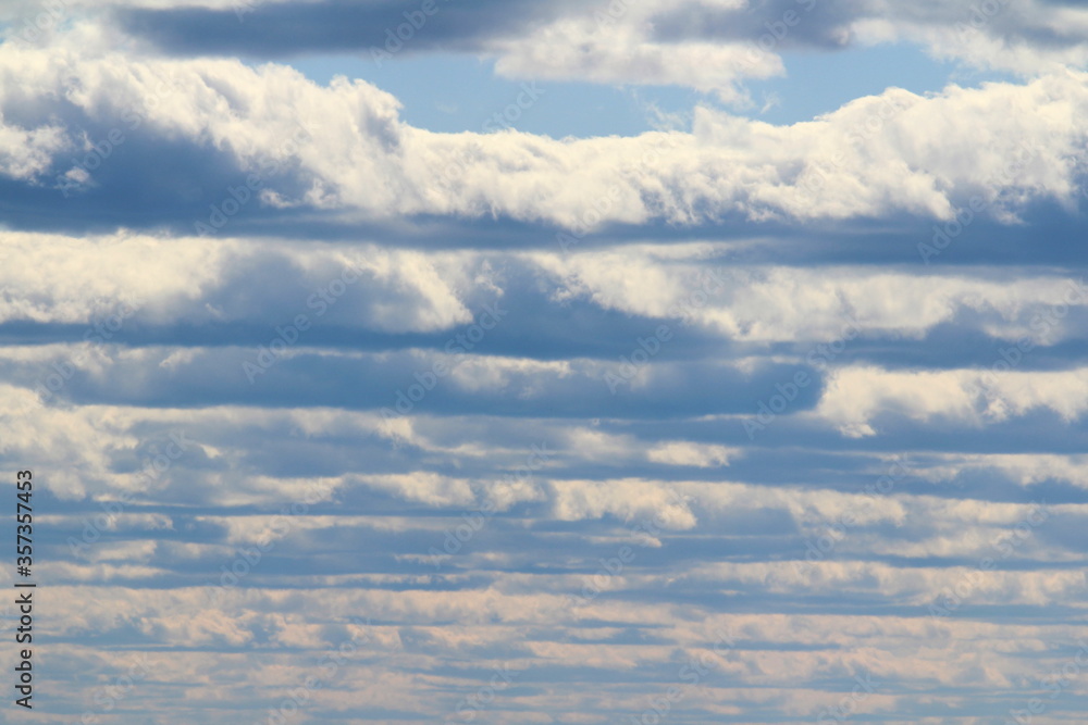 White fluffy clouds on a background of blue sky in summer. The concept of weather and climate White fluffy clouds on a background of blue sky in summer. The concept of weather and climate
