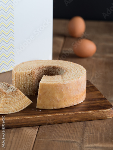 Baumkuchen, translated as tree cake, is a many-layered sponge cake baked on a rotating cylinder close-up on the table. horizontal  photo