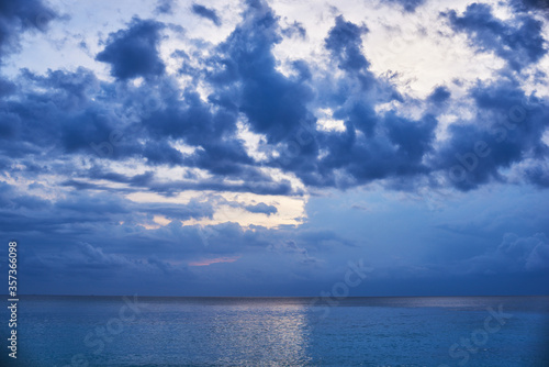 Sunset clouds. The beauty of the sunset. Amazing beach sunset with endless horizon. Sunrise over sea with clouds and horizon in the distance. Nature landscape background with copy space for text. © eskstock