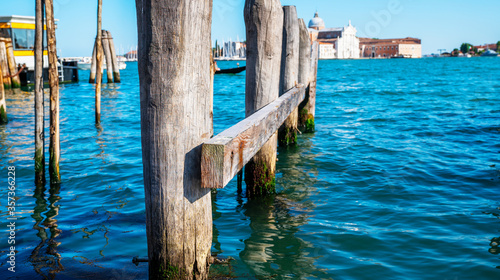 Wooden pillars of old berth in Venice. Vintage style filter effect.