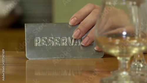Waiter plays with his hand on the reserved sign
